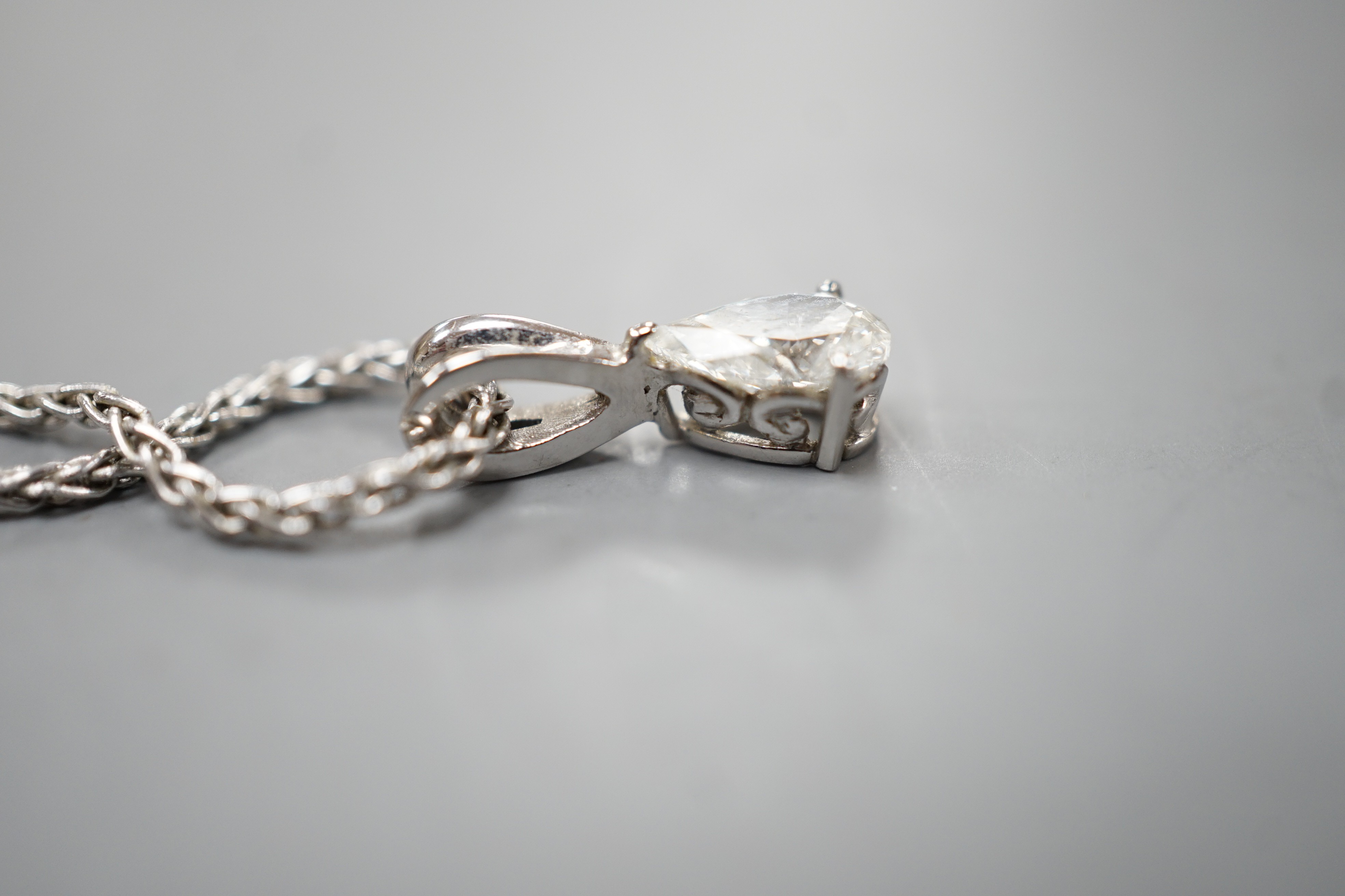 A modern white metal and pear cut diamond set pendant, 13mm, on an 18ct white gold chain, 39cm, gross weight 4.5 grams.